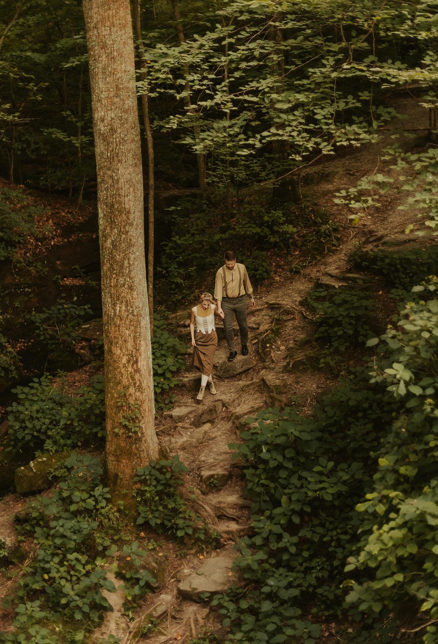 A couple walking through the forest hand in hand in the Pacific North West